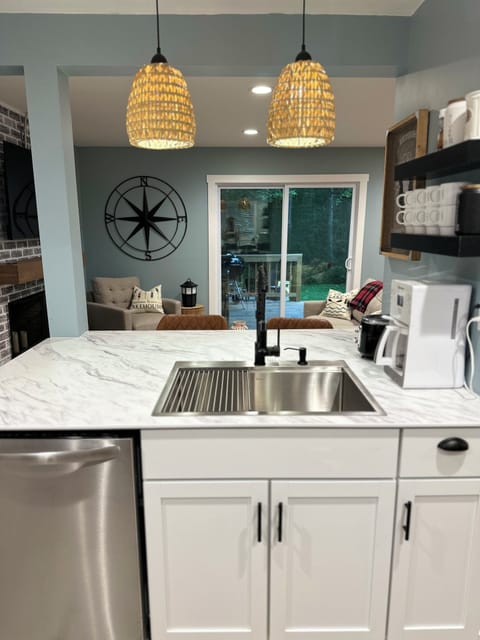 Kitchen overlooking living room with bar stools and plenty of room for prepping 