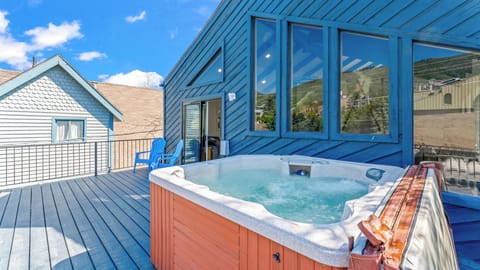 - Private outdoor hot tub with bubbling water and sky views  
- Spacious deck with Adirondack chairs for relaxing outdoors  
- Scenic mountain backdrop creates the perfect retreat