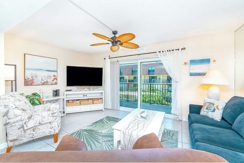 Bright and airy living room with plush seating and a tropical touch, perfect for family gatherings.