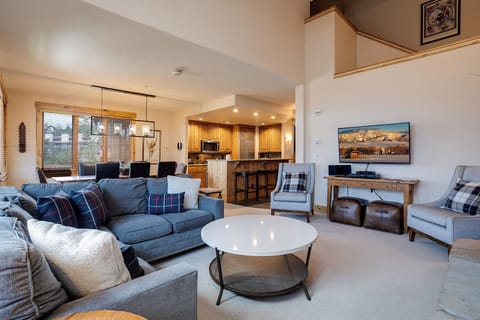 Sink into plush sofas with cozy plaid pillows while watching your favorite shows on the flat-screen TV in this stylish living room.