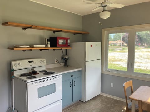 Kitchen with stove, microwave, fridge, cooking tools.
