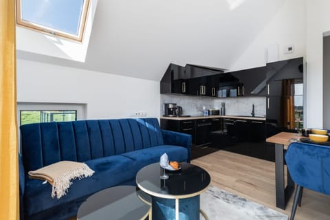 Cozy living area with a blue sofa, modern coffee table, and skylight adding natural light.

