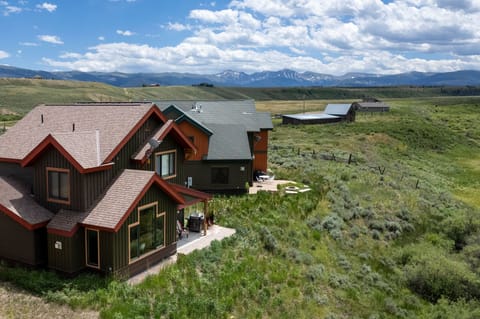 Mountain retreat surrounded by rolling meadows and distant peaks in pristine wilderness setting.