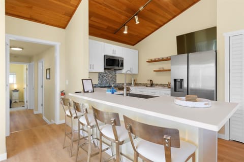 The kitchen has a bar with seats for 4 perfect for gathering together while preparing meals.