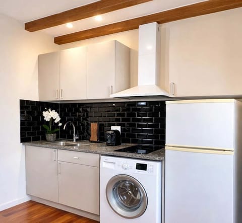 You will find the washer in the kitchen, as well as a Nepresso machine amongst other equipments