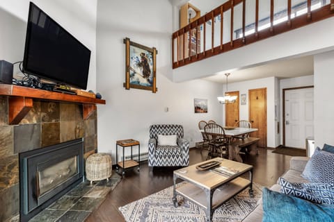 Cozy living room with open loft above, offering a spacious feel and comfortable spot to relax after a day of adventure.