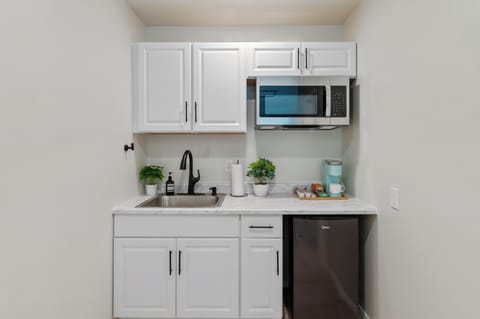 Stocked kitchen w/ mini fridge, microwave, Keurig, and complimentary coffee/tea.