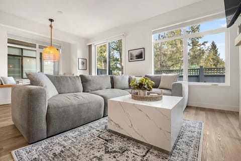 Living room with a gas-lit fireplace, Smart TV, a cozy sectional and walkout access to the backyard/hot tub.