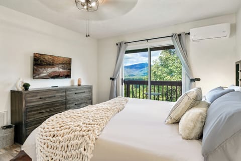 2nd bedroom with bed, dresser, smart tv, and mountain view from this angle.