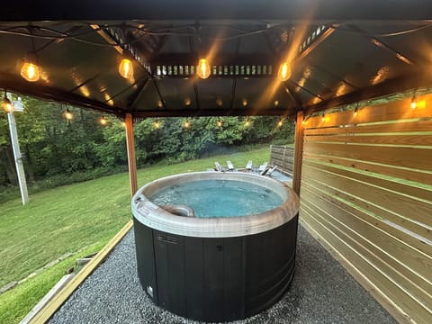 Covered hot tub with privacy screening and warm string lights - perfect for relaxing year-round