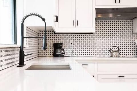 Farm house sink with quartz counters and beautiful backsplash tile!