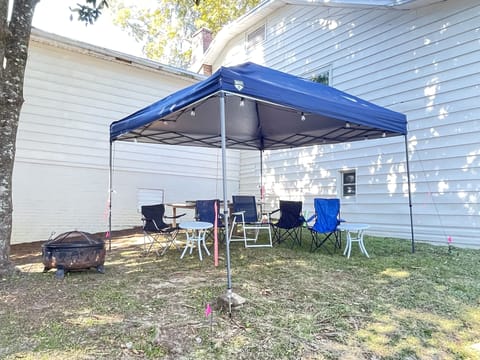 tailgaiting tent with party table, fire-pit, edison lights