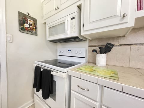 Kitchen has Stove, oven, microwave plus more, and plates, glasses utensils