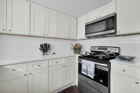Furnished Kitchen with Full fridge, stove, microwave, silverware, plates & pots.