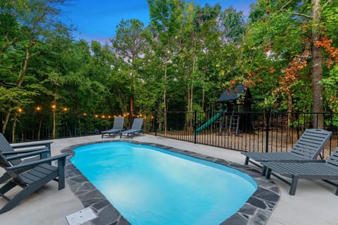 Heated Pool Oasis: Dive into relaxation surrounded by lush trees and twinkling lights!