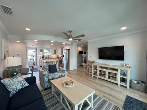Relax in your beautifully appointed living space featuring comfortable seating, modern coastal decor, and open-concept design flowing seamlessly into the kitchen.