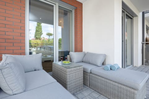 A spacious balcony with comfortable outdoor seating and views of the surroundings.

