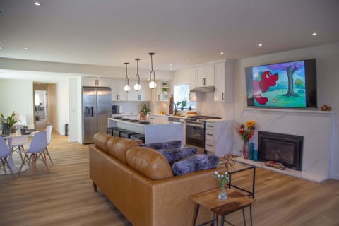 Open-concept kitchen leading into the living room and dining table area.
