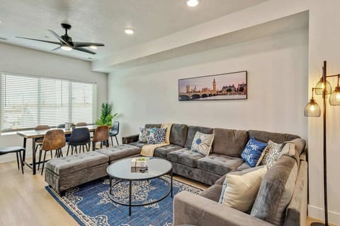 Bright open living area w/ plush sectional, glass coffee table & stylish decor