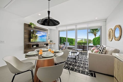 Your bright, modern living space opens to tropical greenery and relaxing outdoor views. Enjoy meals at your dining table, unwind on plush seating, and let the natural light fill your days.
