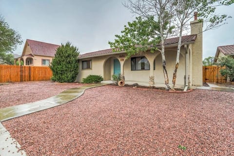 Unit A Main House - Classic stucco home with an arched entry and wide gravel yard—easy arrival, easy lounging. Follow the curved path to the front door beneath tall shade trees.