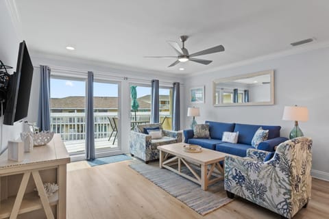 Sink into plush coastal seating and let the ocean breeze drift through your private balcony doors, creating your perfect retreat for relaxation.