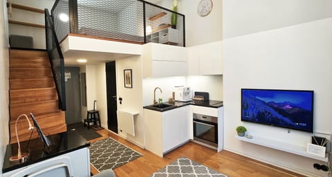 Smart 29 m² loft: full kitchen below, cozy bed upstairs.