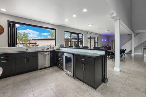 Bar area featuring indoor & outdoor bar seating w/ panoramic window to patio