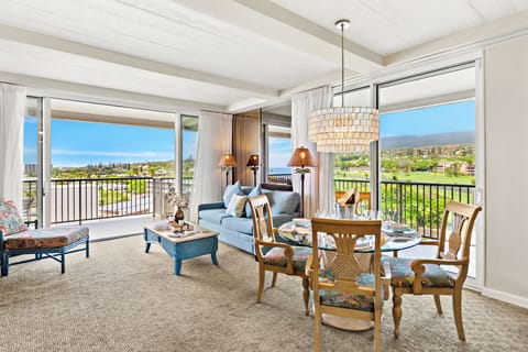 Bright and inviting open-concept living and dining area with elegant furnishings, abundant natural light, and stunning balcony views, creating the perfect coastal retreat