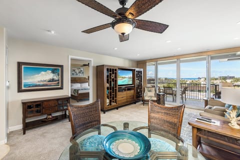 Relax in this bright tropical-themed living space with ceiling fan and spacious balcony overlooking scenic coastal views. Perfect for unwinding after your island adventures.