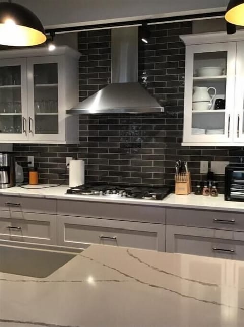 Kitchen with quartz countertops, and 10’ island, wine cooler and farm sink.