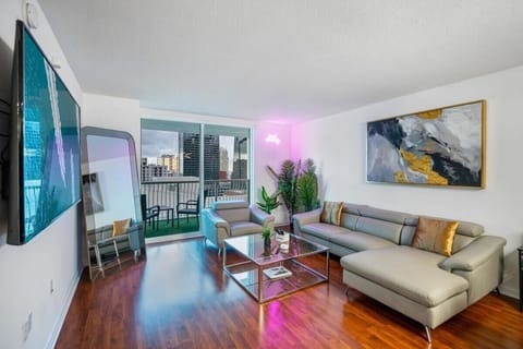 Modern living room with leather seating and city views from the balcony