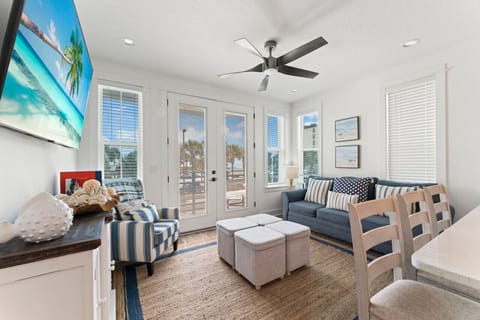 Spacious living room with a large Smart TV, and comfy seating—plus a balcony where you can relax and listen to the ocean.