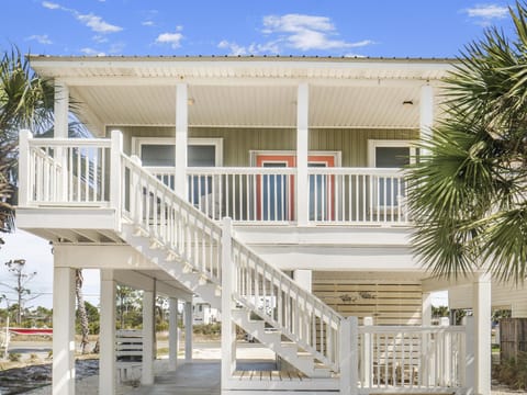 Coastal beach house with elevated design and palm trees creating the perfect island getaway atmosphere.