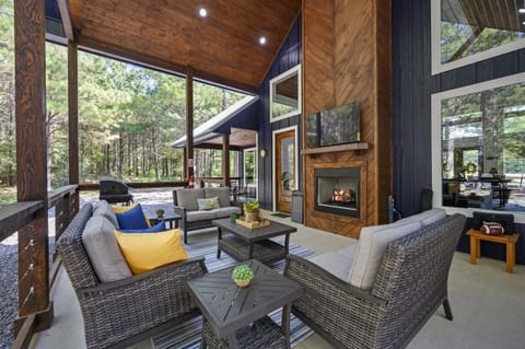 Covered outdoor porch with a fireplace and smart TV