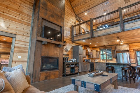 The grand room here at Wildcat Lodge features a custom metal wrapped two-story fireplace equipped with a large screen TV.