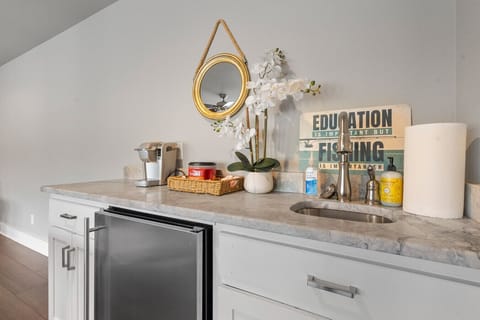 Convenient wet bar setup with mini fridge and stylish décor.