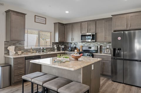 Fully equipped kitchen with stainless steel appliances and bar seating.
