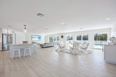Open-concept living area with waterfront views and modern white furnishings.