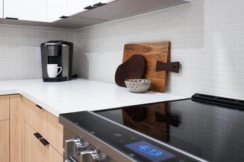 Fully equipped kitchen boasting stainless-steel appliances and an island offering bar seating. Kitchen fully stocked with all culinary essentials for ease and convenience.