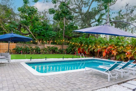 Relax in the tropical palm tree lined backyard with a 4 hole putting green, bocce court, outdoor sectional, pool loungers, outdoor dinning for 10 and a year round heated salt water pool.