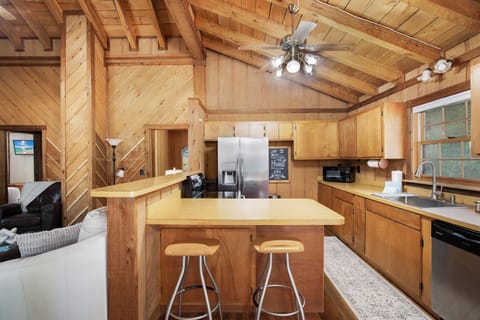 Your rustic cabin kitchen awaits with warm wood beams overhead and modern appliances for cozy meal preparation.