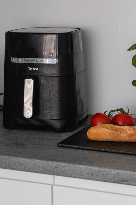 A modern coffee machine and fruit displayed on the countertop, adding convenience and style.