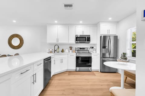 A beautifully designed spacious and modern kitchen with white shaker cabinets, marbled quartz countertops, stainless steel appliances, ice maker and fully equipped with everything you need to serve 6 - 8 guests.