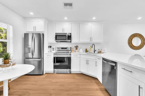 A beautifully designed spacious and modern kitchen with white shaker cabinets, marbled quartz countertops, stainless steel appliances, ice maker and fully equipped with everything you need to serve 6 - 8 guests.