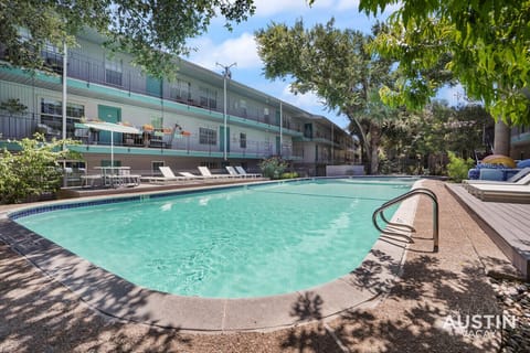 Gorgeous pool area with lounge chairs, shade, and picnic tables