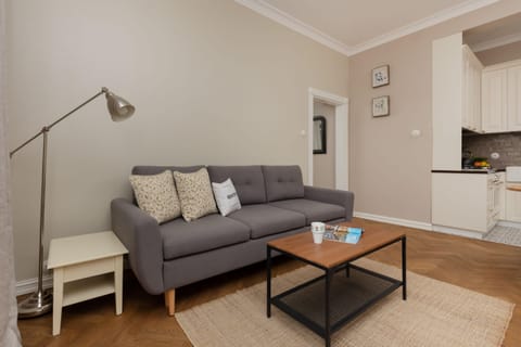 A cozy living room with a gray sofa, a coffee table, and neutral tones creating a relaxing ambiance.

