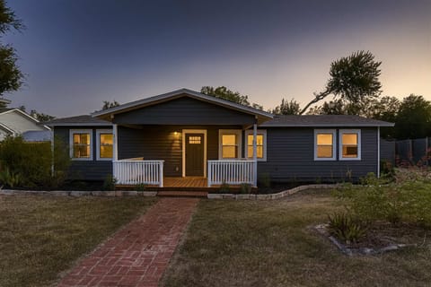 Inviting front entry with lush greenery and a well-maintained lawn.