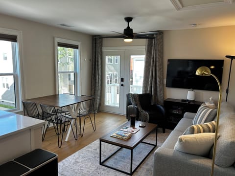 Living area with 4 person dining set, leather chair, TV with streaming services