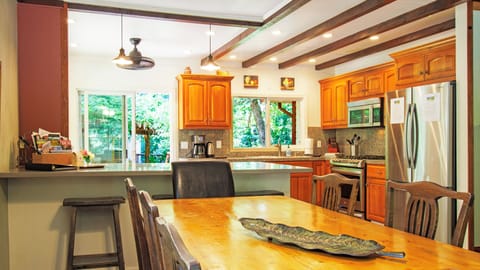 Bar seating for 3 adjacent to dining table in open floor plan kitchen.